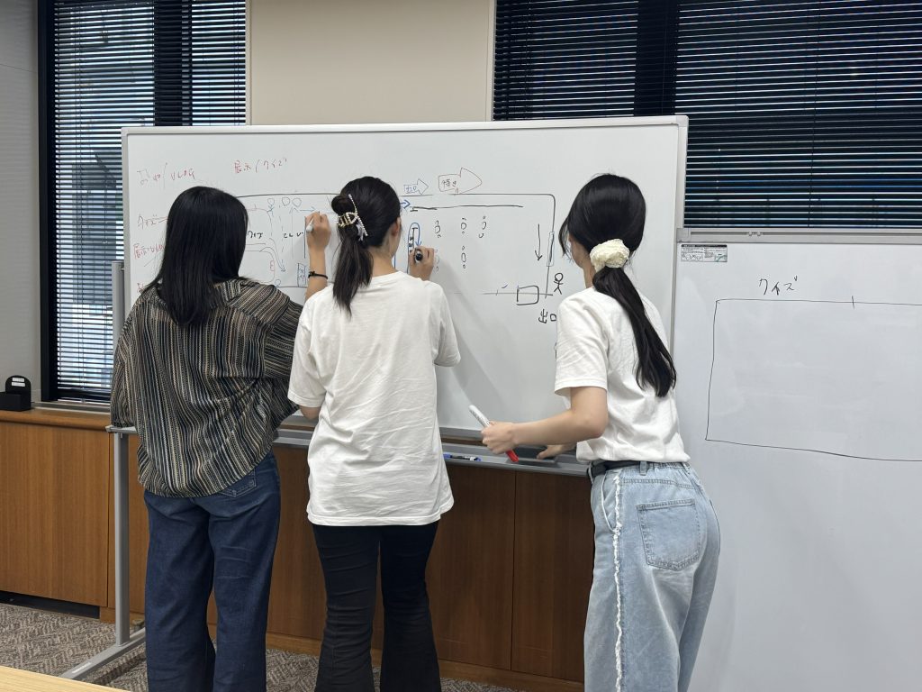 学生がホワイトボードの前で協議しています