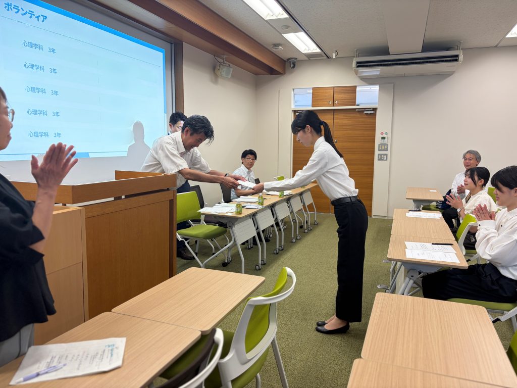 学生が委嘱状を受け取っている